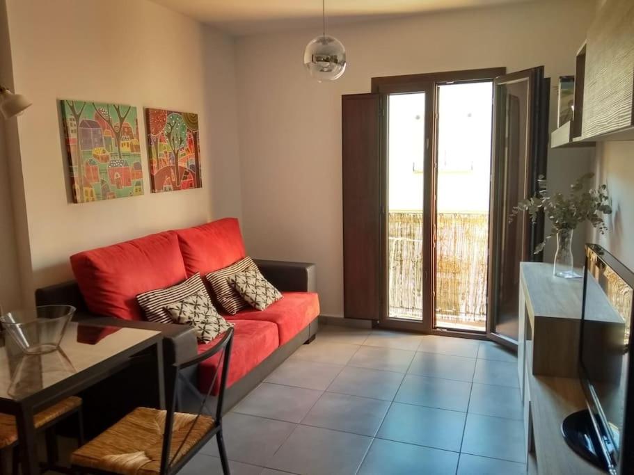 een woonkamer met een rode bank en een tafel bij Fabuloso apartamento en Triana in Sevilla
