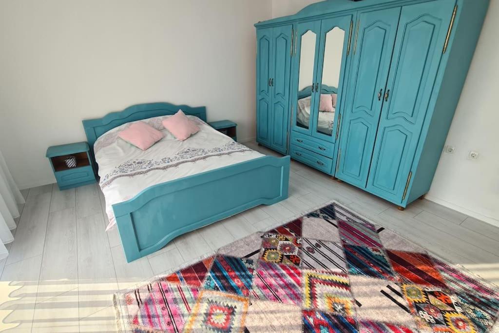 a bedroom with a blue bed and a blue cabinet at Pristina Apartments in Prishtinë
