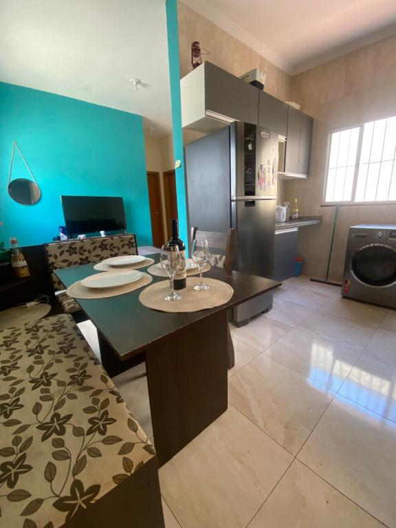 una cocina con una mesa con copas de vino. en Apartamento Bela vista II, en Guaratinguetá