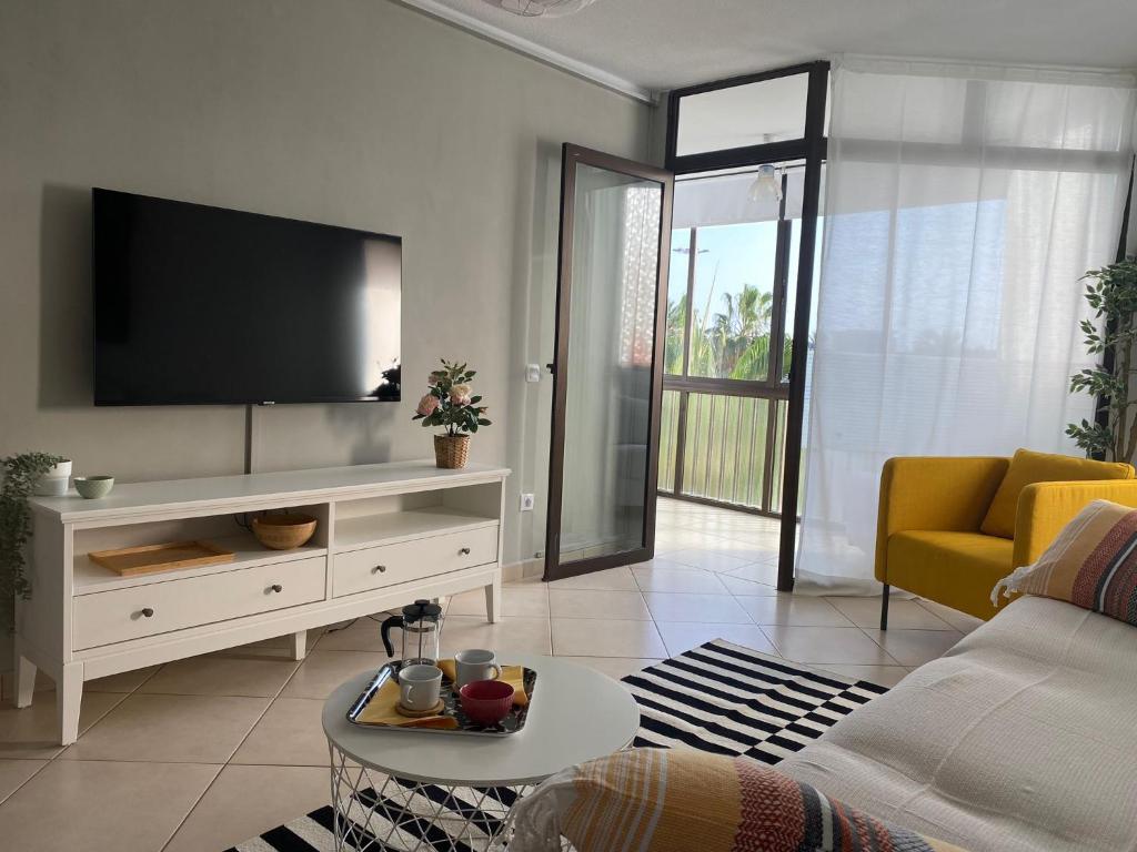 sala de estar con TV de pantalla plana en la pared en Jandia Beach Apartment en Morro del Jable