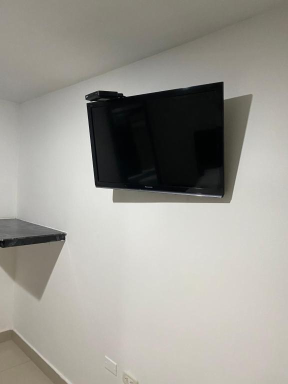 a flat screen tv hanging on a white wall at Hotel Estefanía Princess 84 in Barranquilla