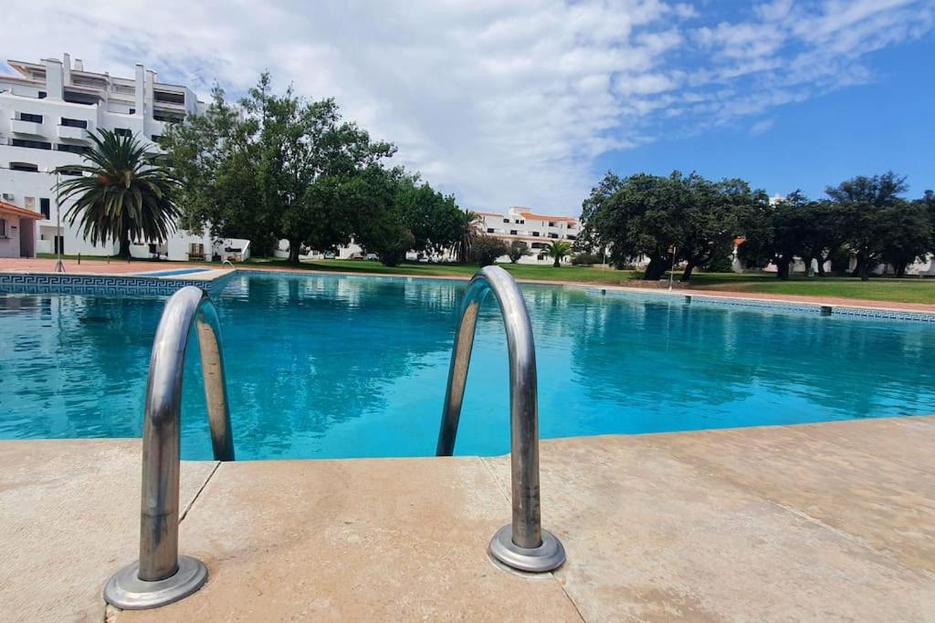una piscina con dos barras de metal delante en Oura Vilanova - Beach, Pool & Garden, en Brejos