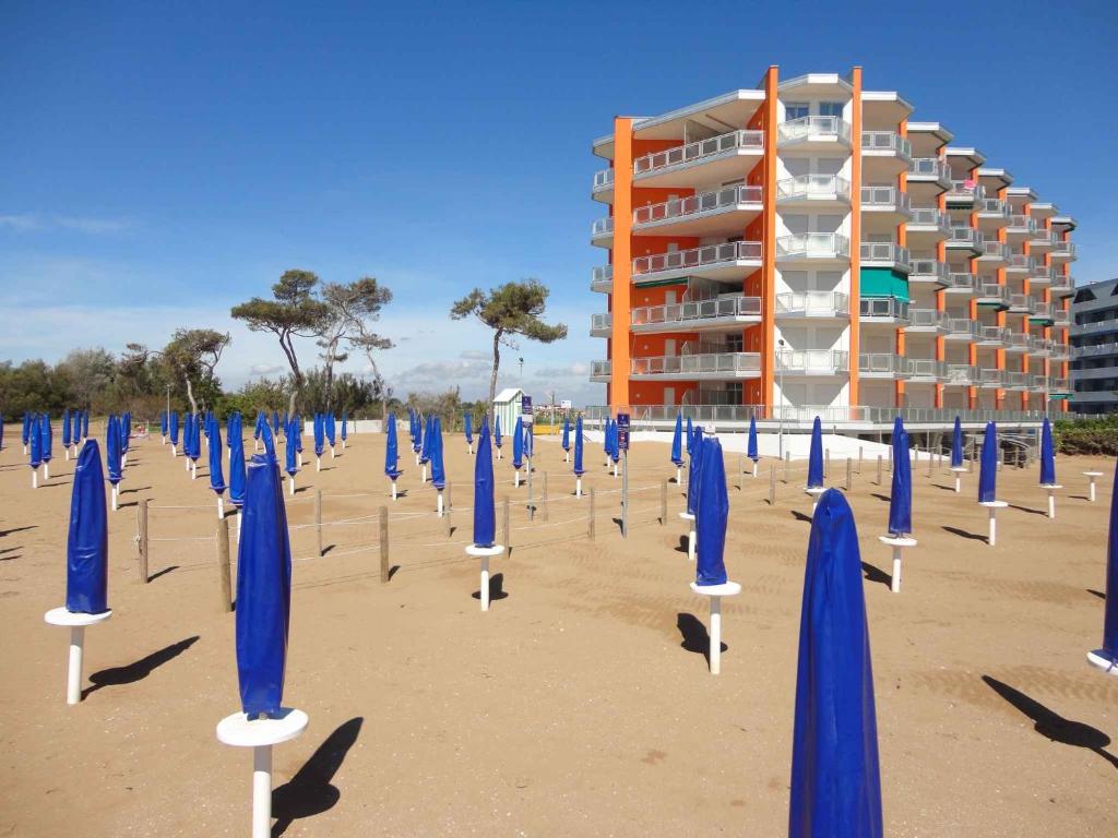 a bunch of blue umbrellas on the beach at Apartment in Porto Santa Margherita 43993 in Porto Santa Margherita di Caorle