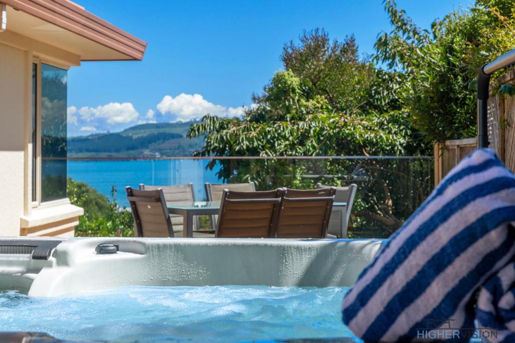a hot tub with a view of the water at Tui Lookout - Spa Pool & Lake Views in Taupo