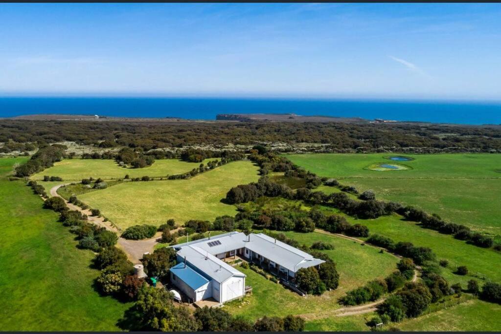 an aerial view of a large house with the ocean in the background at Pt Hesse Luxury Coastal Homestead in Port Campbell