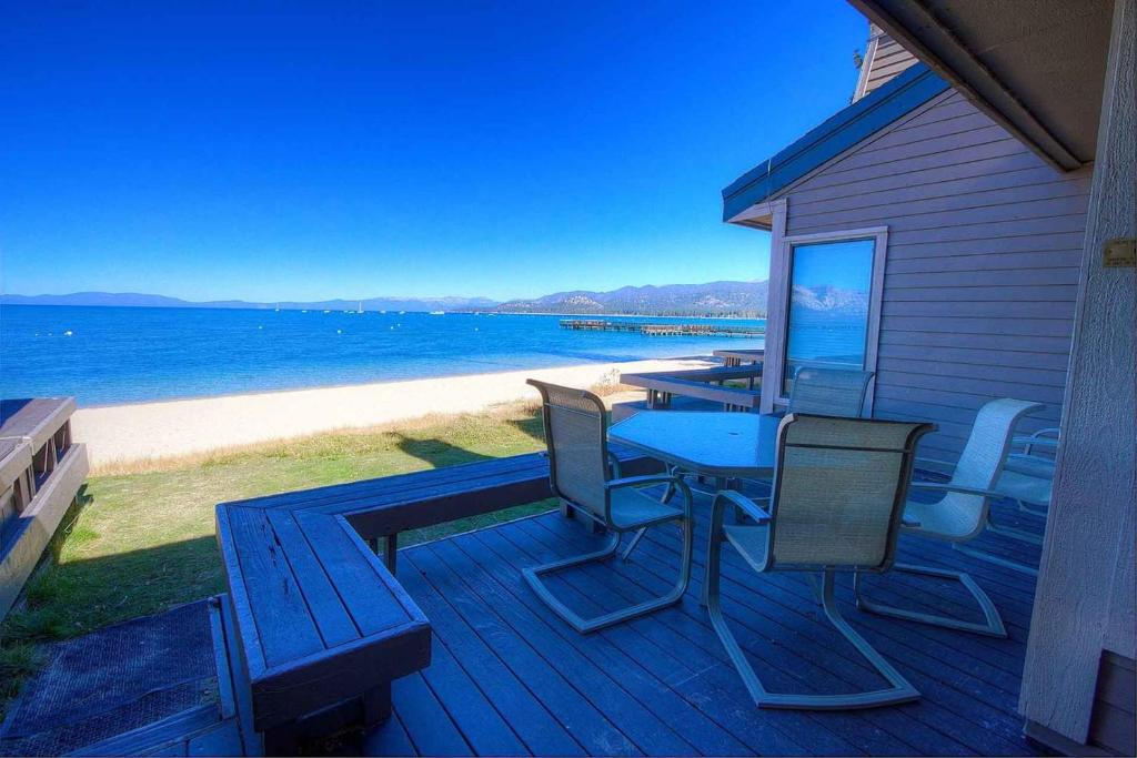 a deck with a table and chairs on the beach at Sky Lake Splendor condo in South Lake Tahoe