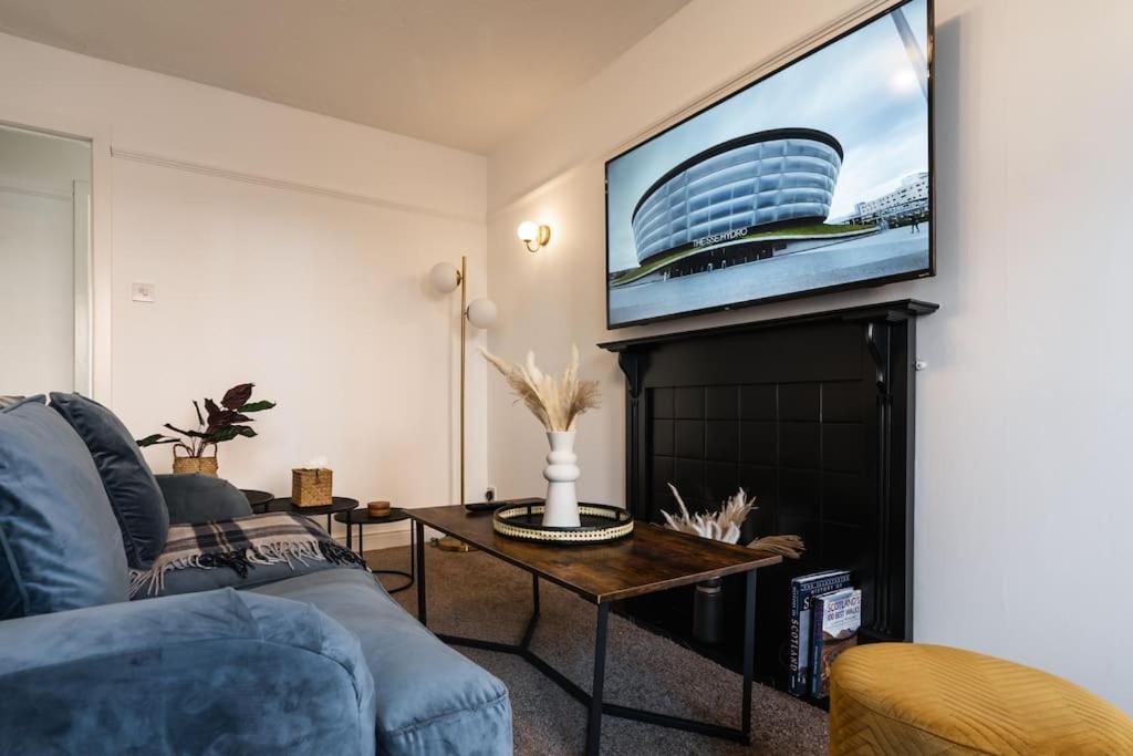 a living room with a couch and a tv on a wall at The Hydro Escape - 5* Event Venue *Free Parking* in Glasgow