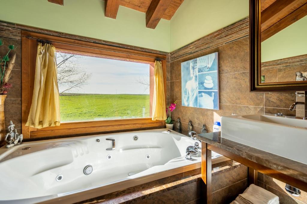 baño grande con bañera y ventana en A Toca Casas Rurales en Turegano Segovia en Turégano