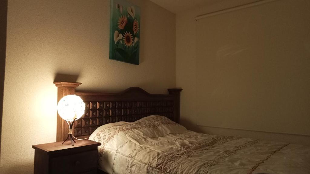 1 dormitorio con 1 cama con lámpara en una mesita de noche en Confortable casa de descanso para fin de semana, en Tlayecac
