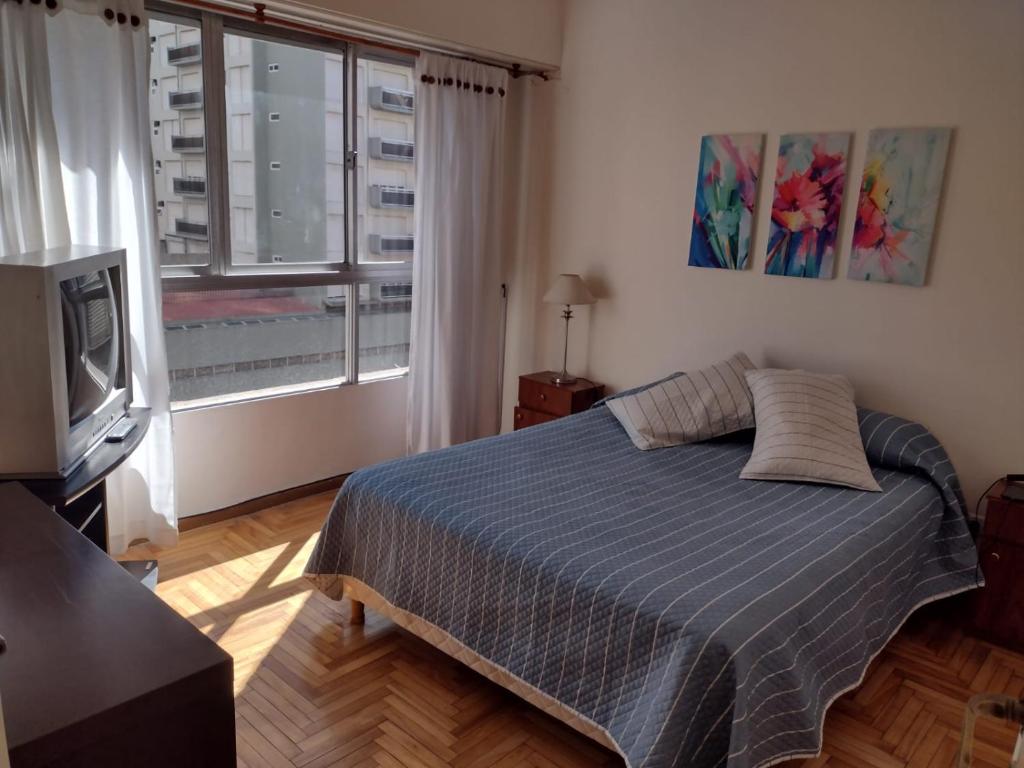 1 dormitorio con 1 cama, TV y ventana en Edificio VALLE & VALLE en Mar del Plata
