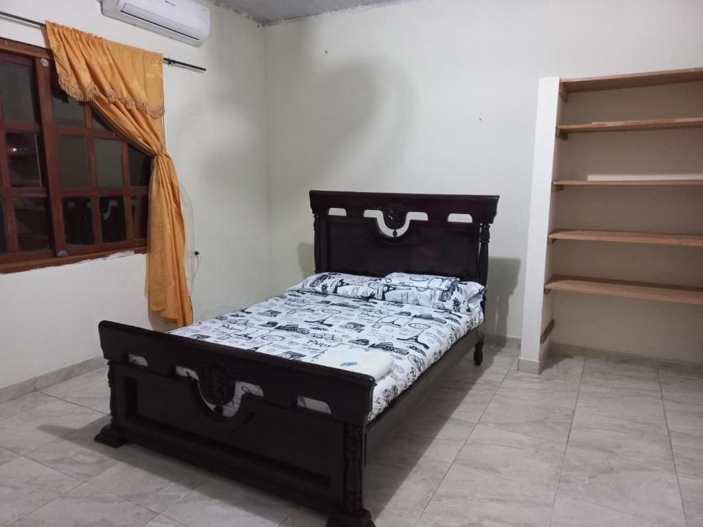 a bed sitting in a room next to a shelf at Casa de los Cruz in Leticia