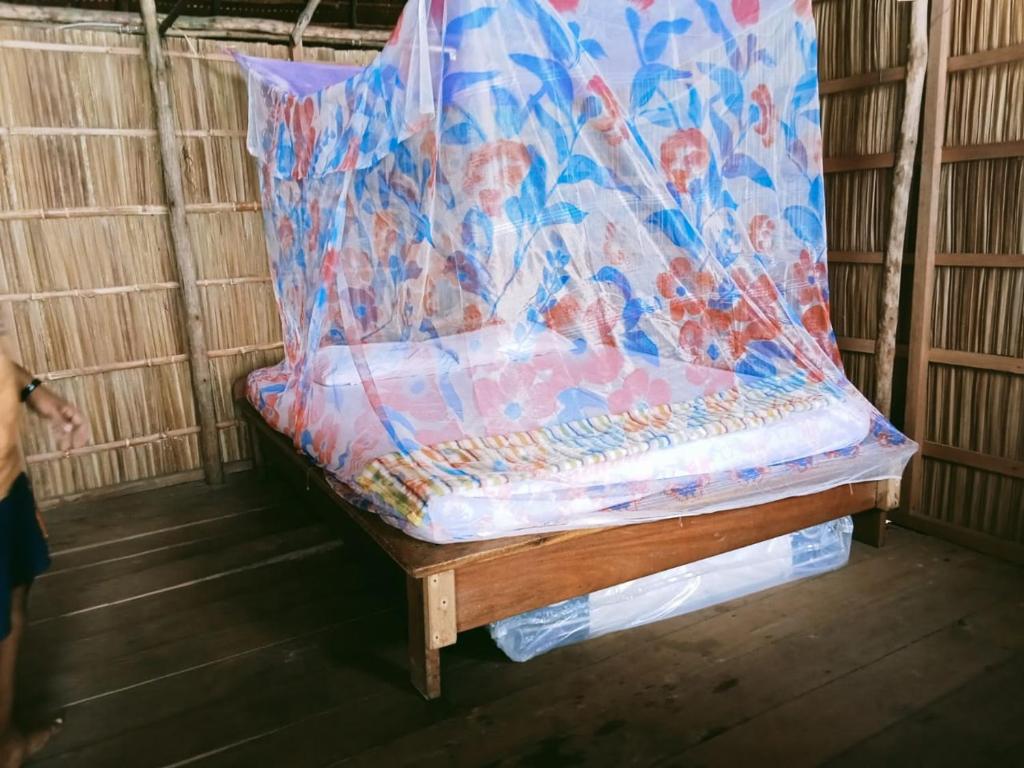a bed in a room with a covering on it at Biryei Homestay in Pulau Birie