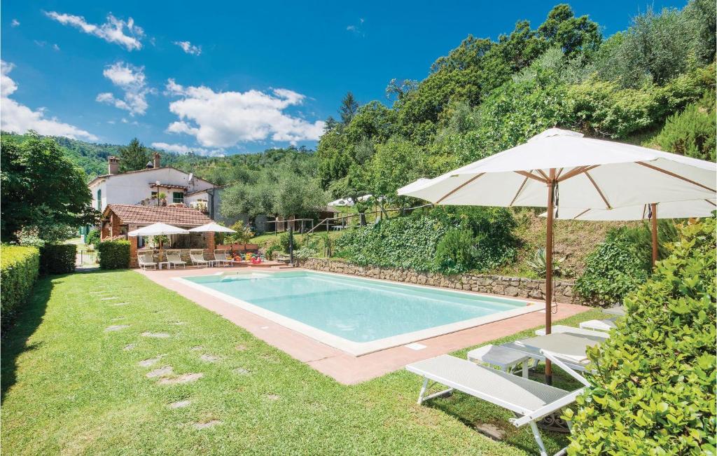 a swimming pool with an umbrella and two lawn chairs and an umbrella at Linda in Cireglio