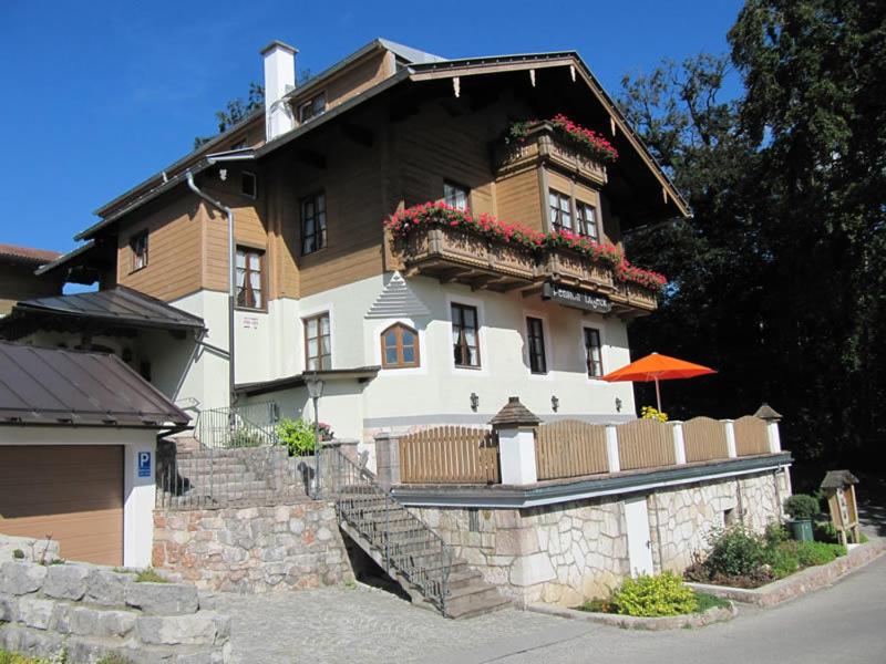 duży biały dom z kwiatami na balkonie w obiekcie Pension Lugeck w mieście Berchtesgaden