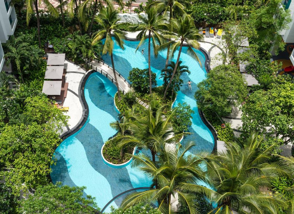 an aerial view of a resort pool with palm trees at Chatrium Residence Sathon Bangkok in Bangkok