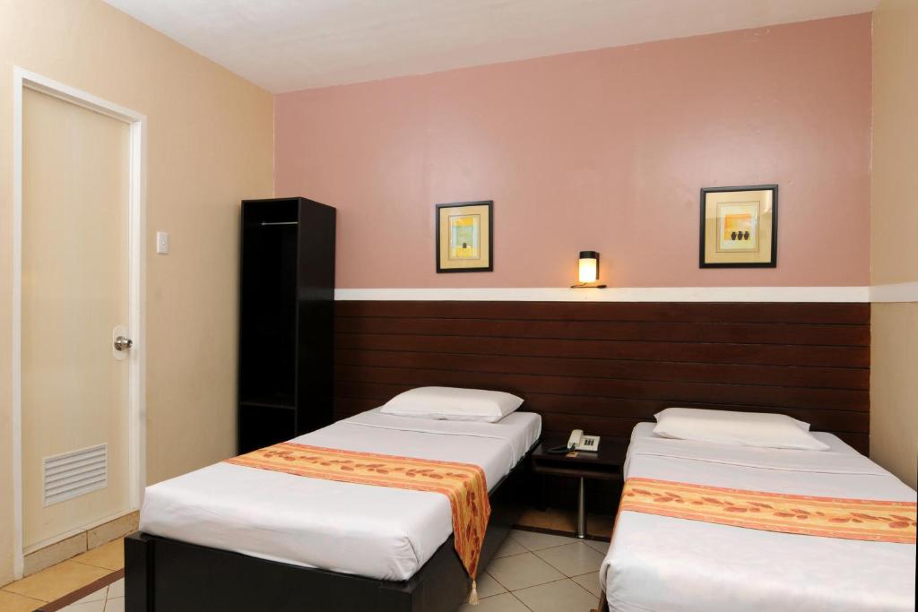 Postel nebo postele na pokoji v ubytování Sampaguita Suites JRG