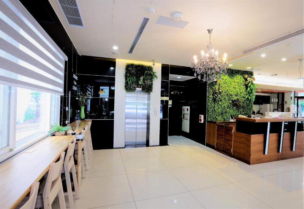 un restaurante con un bar con plantas en las paredes en Huang Shin Business Hotel-Shang An, en Taichung