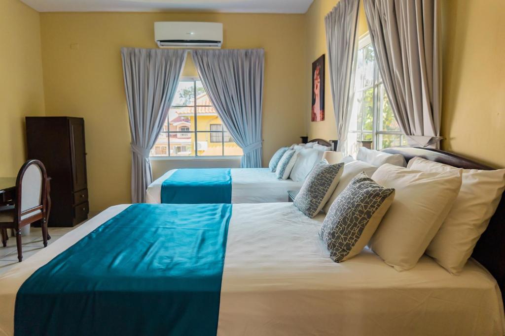 a bedroom with two beds and a window at Art Hotel Boutique in San Pedro Sula