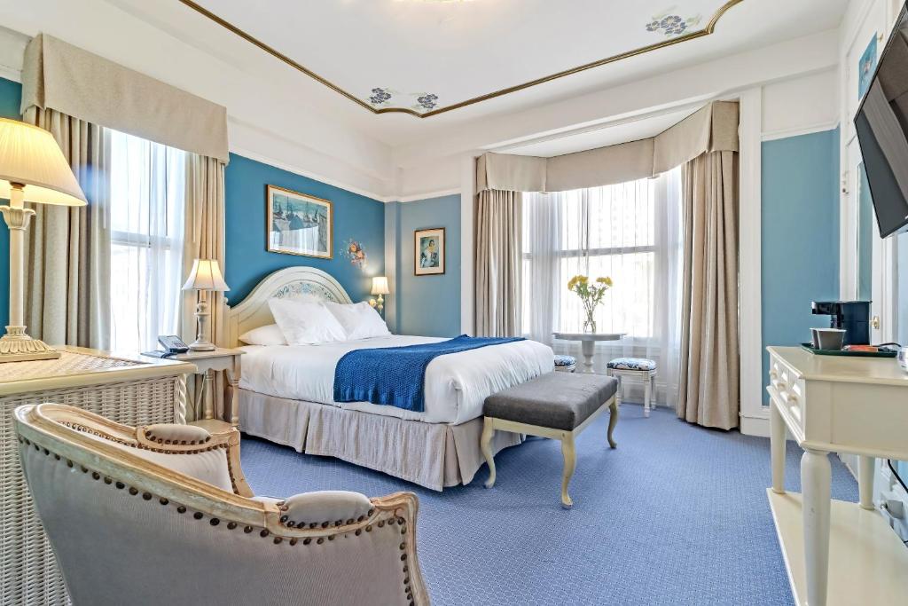 a hotel room with a bed and a television at Cornell Hotel de France in San Francisco