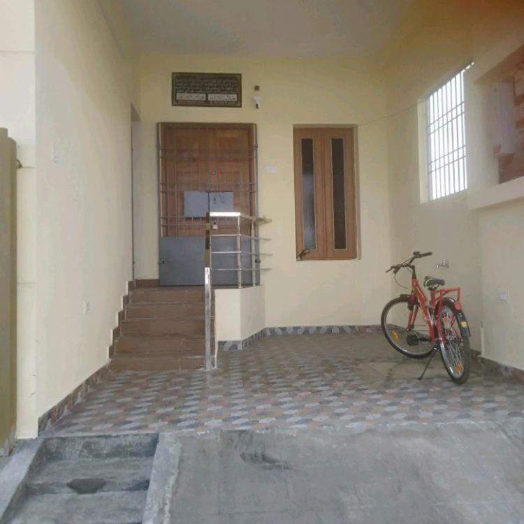 a red bike parked in a building with a staircase at ARS furnished house in Chrompet