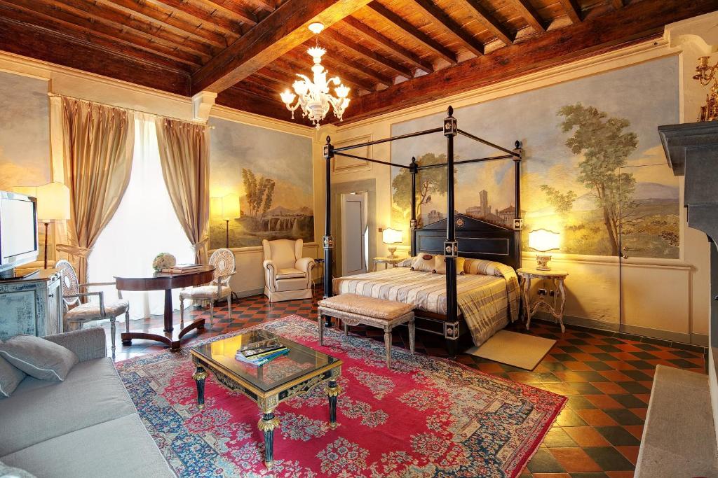 een slaapkamer met een bed en een woonkamer bij Villa Il Sasso - Dimora d'Epoca in Bagno a Ripoli