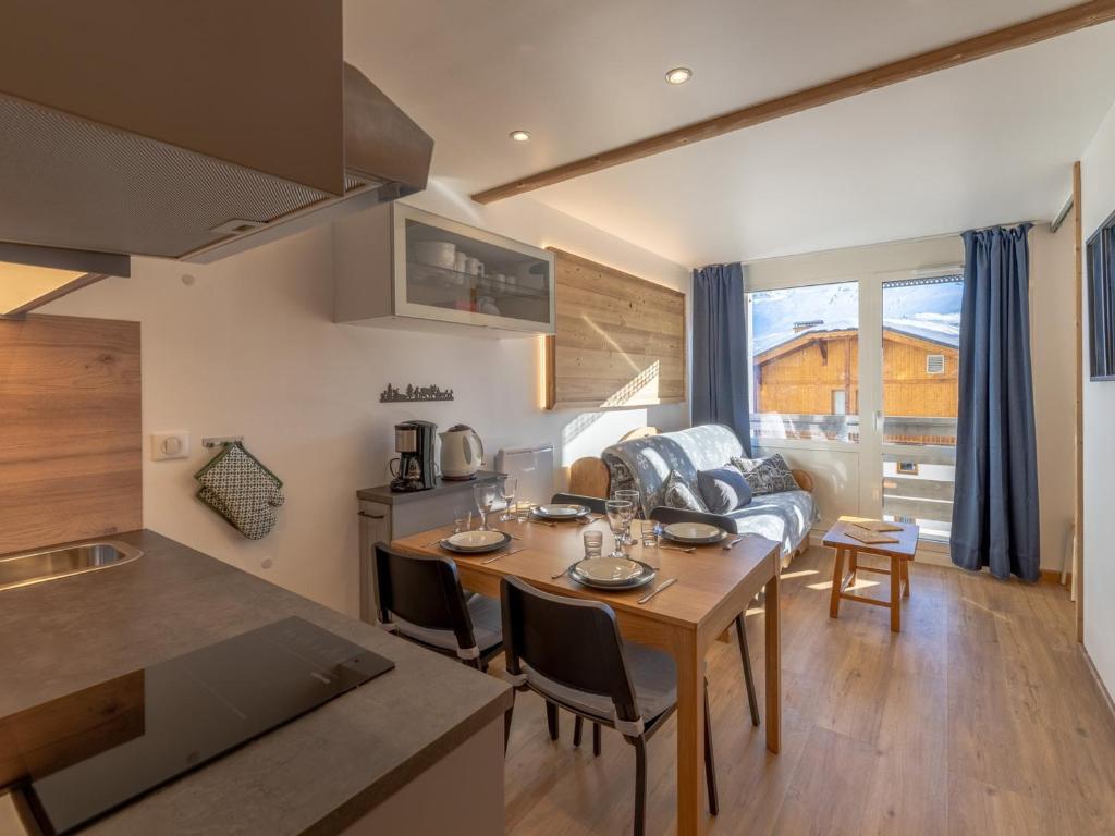 a kitchen and living room with a table and a couch at Appartement rénové proche des pistes avec WiFi et linge inclus - FR-1-640-10 in Val Thorens