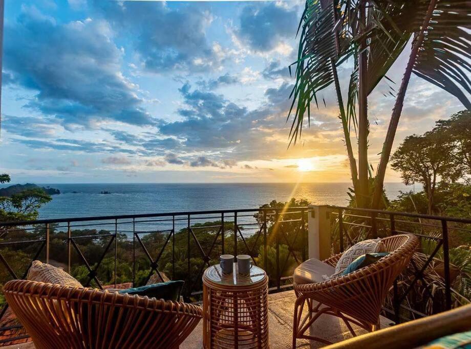 a patio with chairs and a table with a view of the ocean at Villa Amor del Mar with Breathtaking View of Ocean & Jungle in Dominical