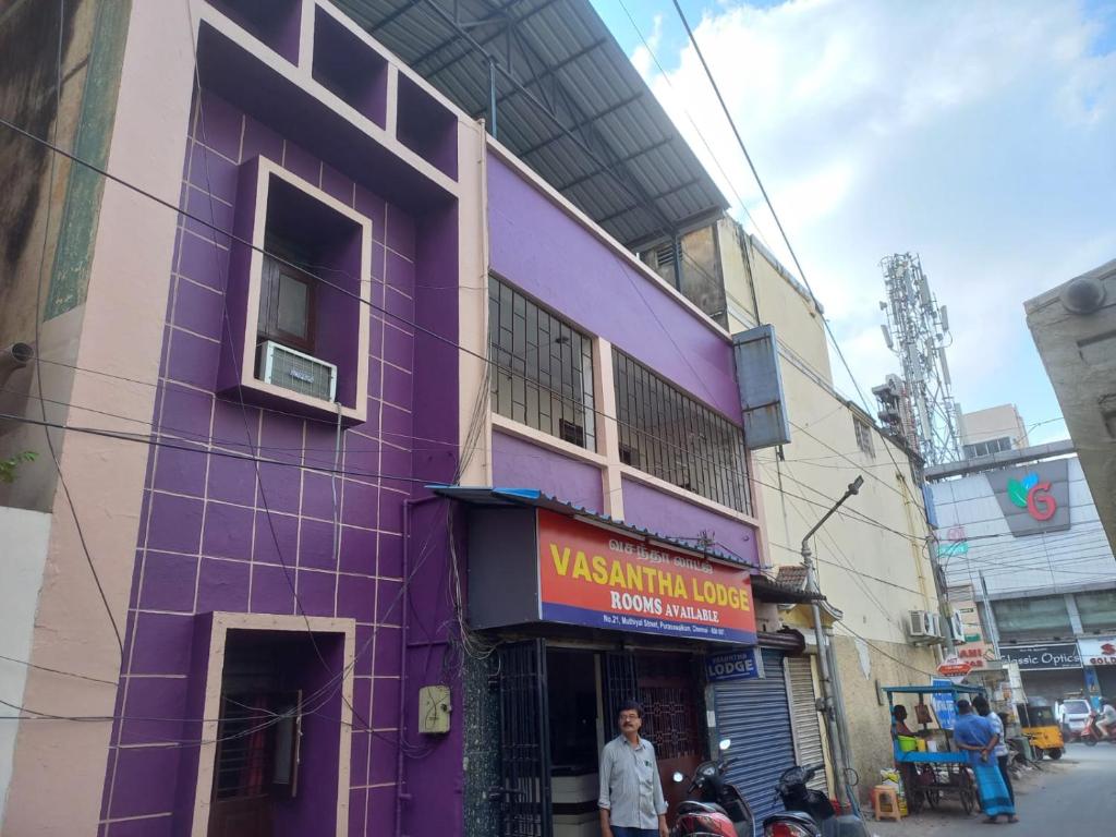un edificio púrpura al lado de una calle en Vasantha Lodge Purasawalkam chennai, en Chennai