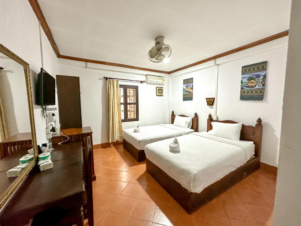 Cette chambre comprend deux lits et une télévision. dans l'établissement Chaliya Boutique Garden, à Luang Prabang