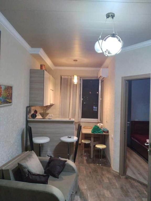 ein Wohnzimmer mit einem Sofa und einer Küche in der Unterkunft qood plase in Tbilisi City