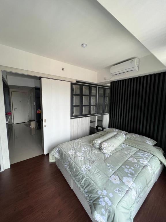 - une chambre avec un lit et une couette noire et blanche dans l'établissement Apartment Breeze Bintaro, Tangerang Selatan, à Pondoklang