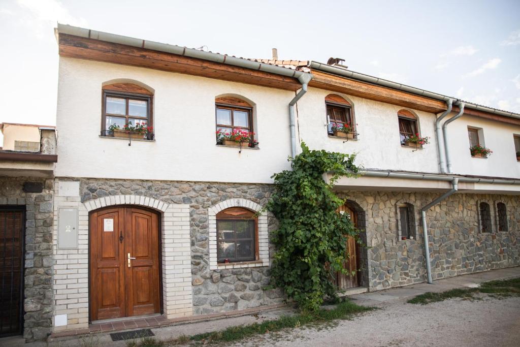 una antigua casa de piedra con ventanas y puertas en Vinný Sklep U Terezy a Jakuba, en Moravská Nová Ves