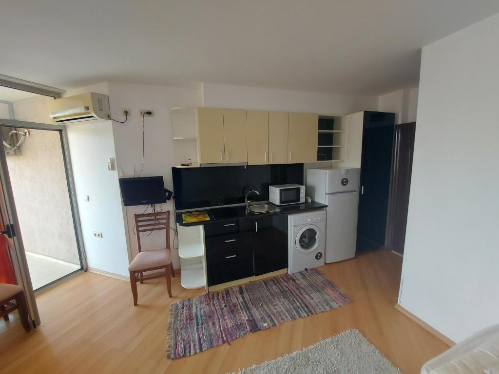 a small kitchen with a stove and a microwave at Studios & Apartments Perla in Sunny Beach