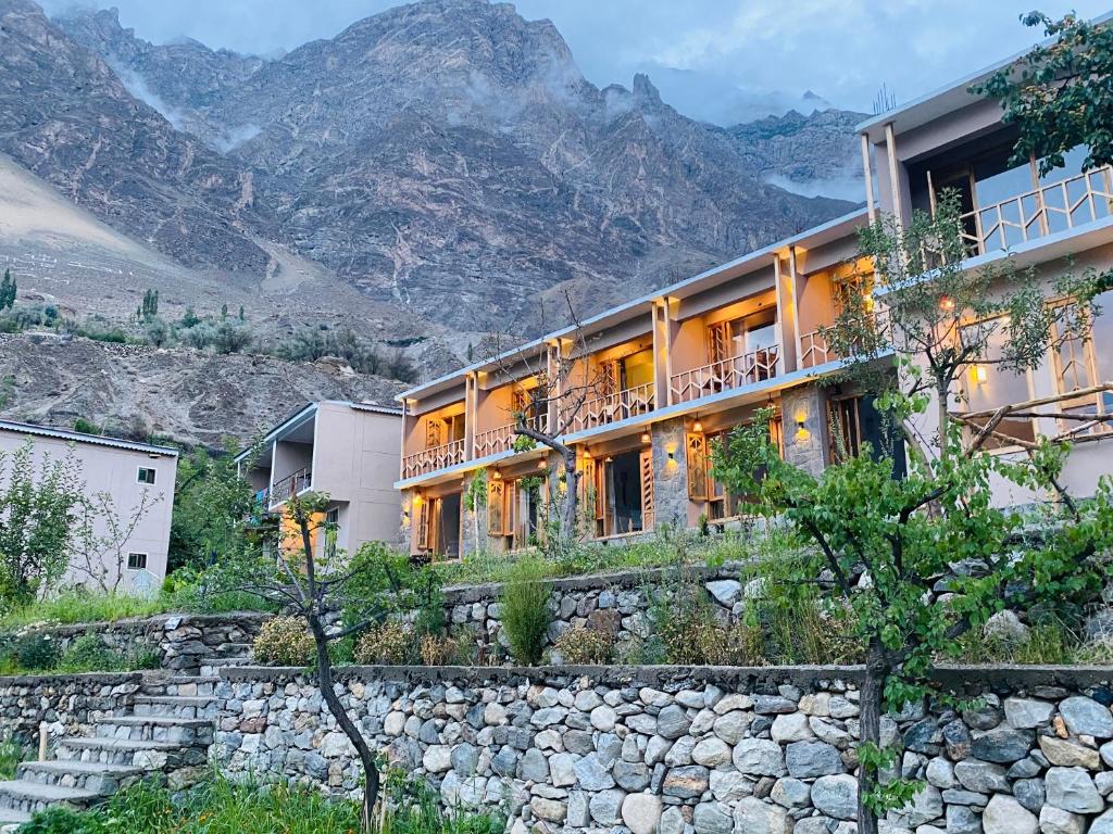 ein Gebäude auf einem Hügel mit Bergen im Hintergrund in der Unterkunft applegardenhunza in Alīābād