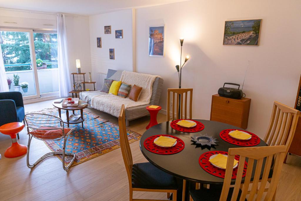 un salon avec une table et un canapé dans l'établissement Parc Blandan - T2 calme lumineux et bien situé., à Lyon