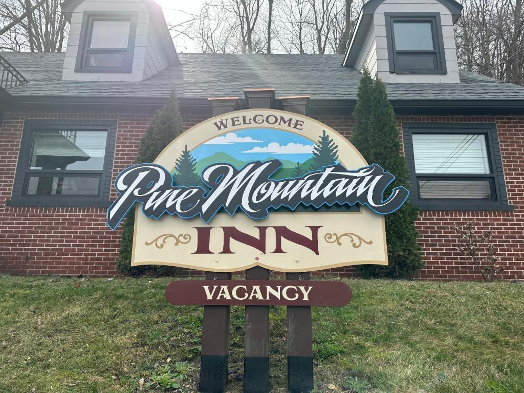 una señal para una posada de montaña de pino frente a una casa en Pine Mountain Inn, en Pineville