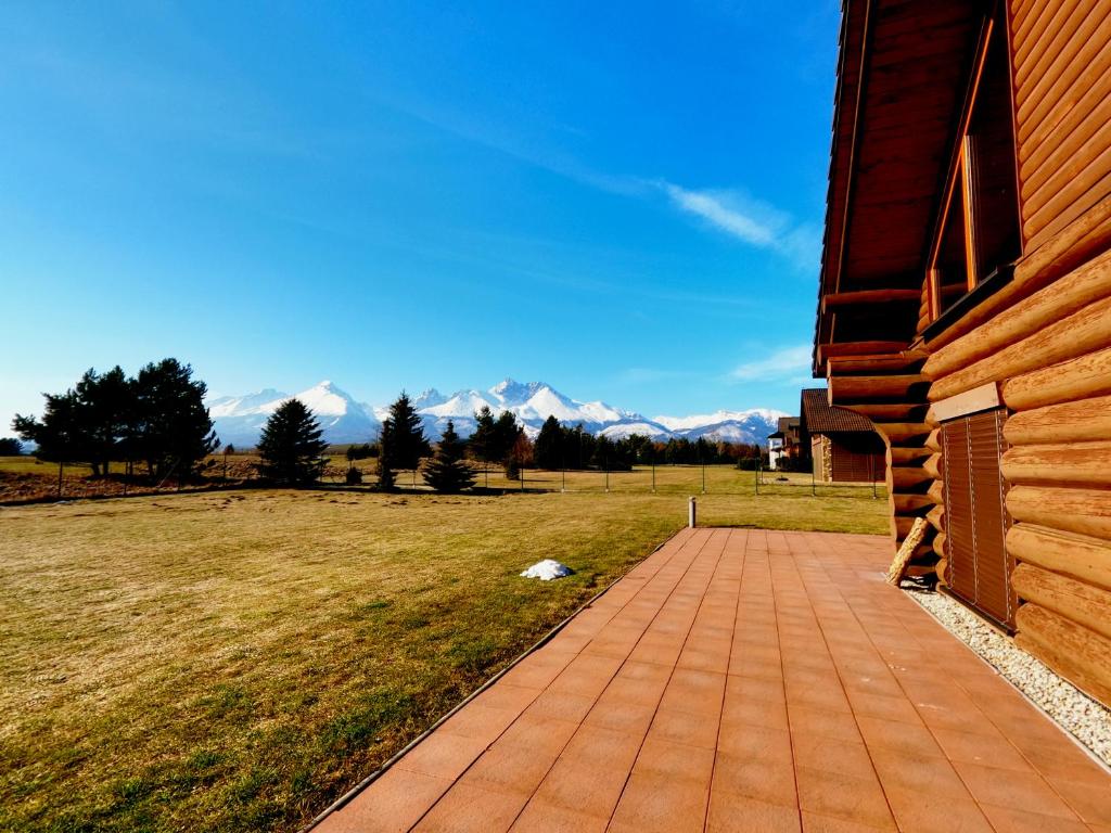 a brick walkway next to a house with mountains in the background at Lodge Tatras in Veľká Lomnica