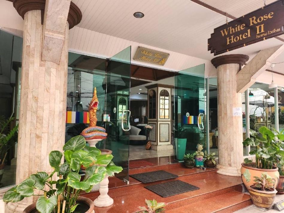 Nong Prue的住宿－White Rose​ Hotel​ II​，一座白色的房子,里面栽有盆子植物