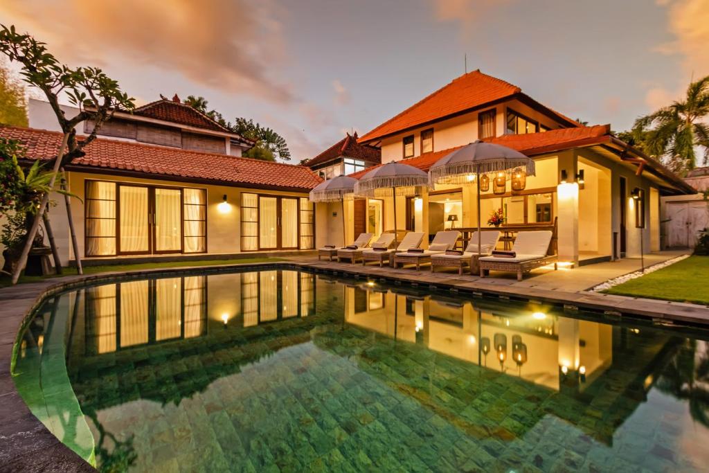 a house with a swimming pool in front of a house at Villa Senan in Seminyak