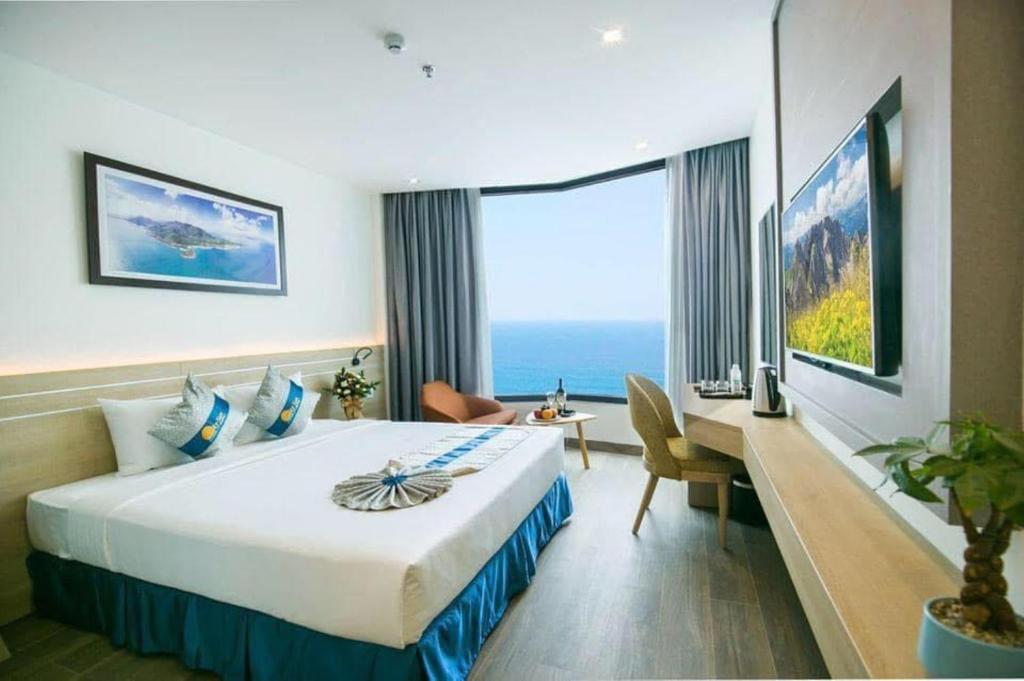 um quarto de hotel com uma cama grande e uma secretária em Lucky Sun Hotel em Nha Trang