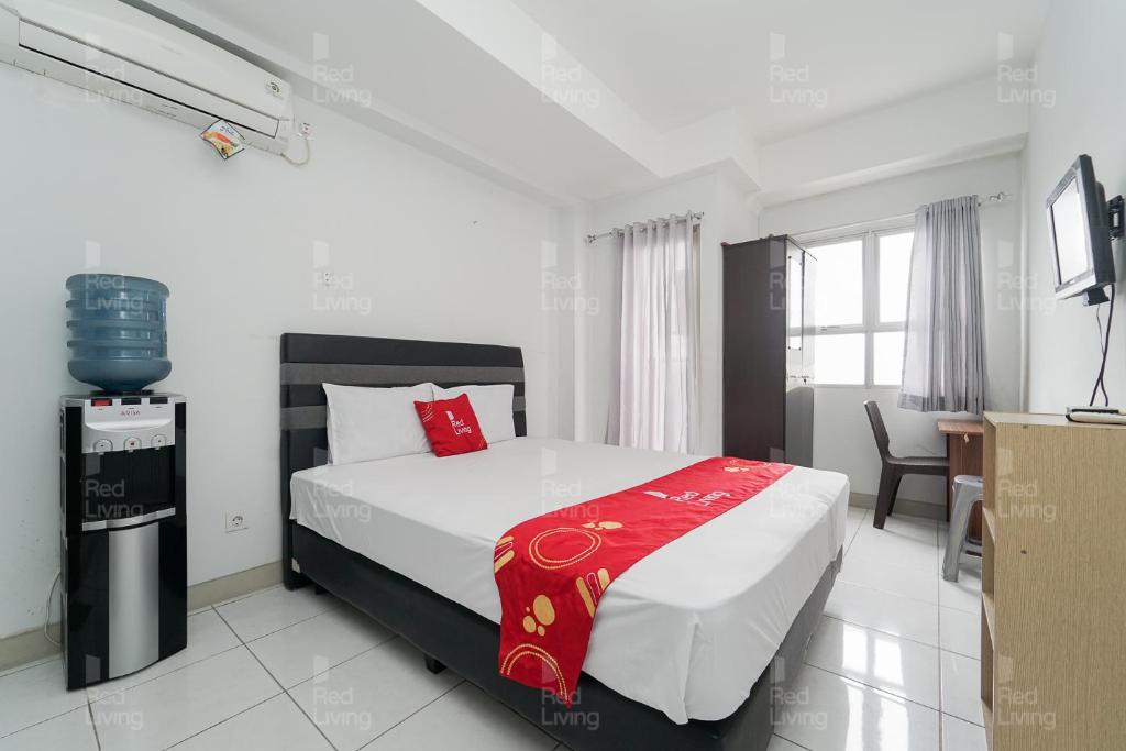 a bedroom with a bed with a red blanket on it at RedLiving Apartemen Mekarwangi Square - Agus 3 Tower A in Bandung