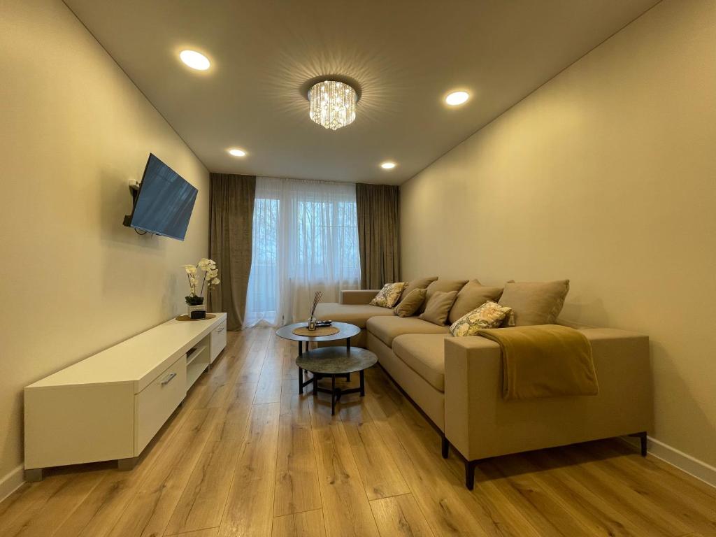 a living room with a couch and a tv at Apartamentai 128 in Panevėžys