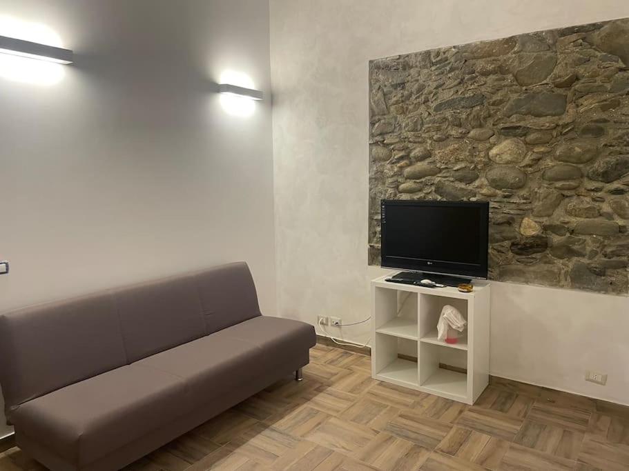 een woonkamer met een bank en een flatscreen-tv bij Bilocale finemente ristrutturato in Letojanni