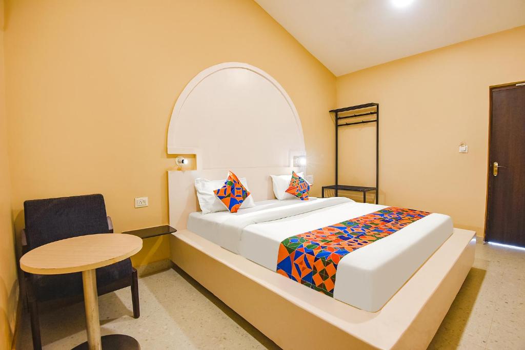 a bedroom with a large bed and a table at FabEscape Kautilyaa Resort With Swimming Pool 