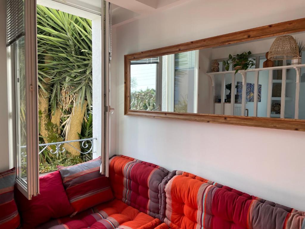 a red couch in a room with a window at LA CHOUETTE DU LAC MARION in Biarritz