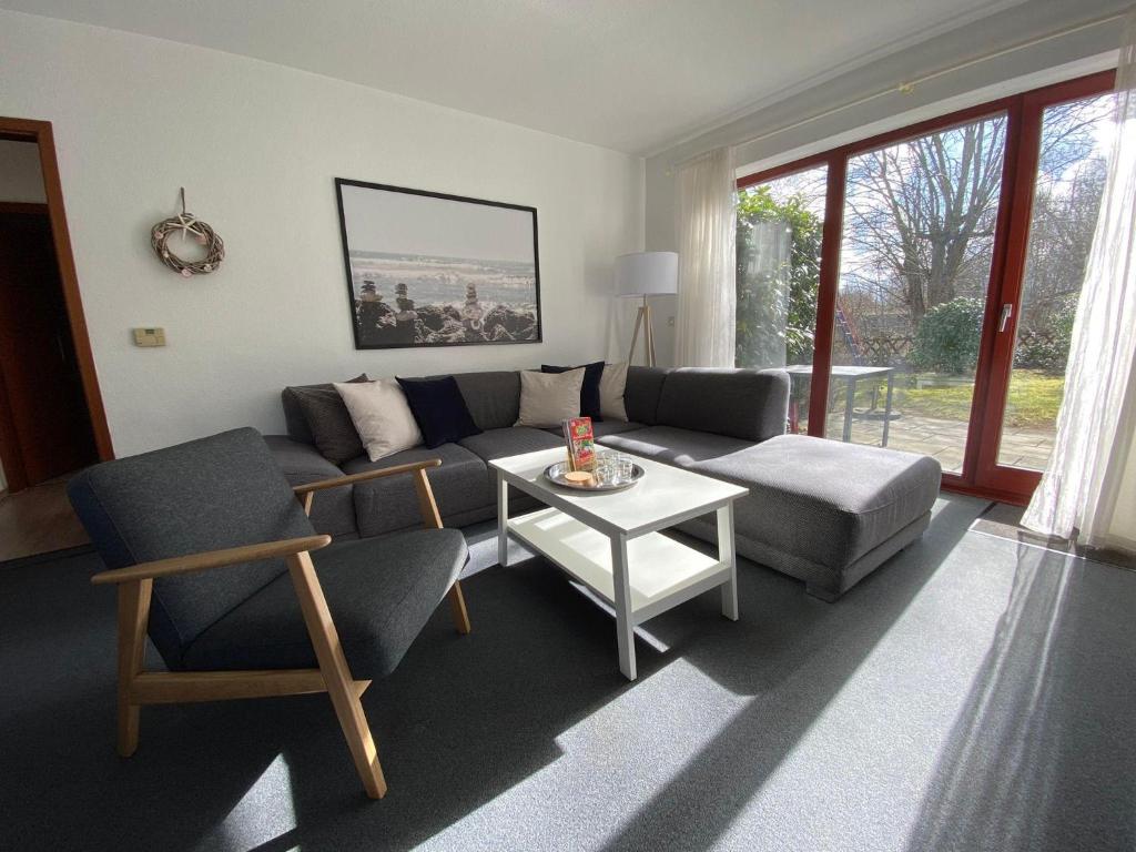 a living room with a couch and chairs and a table at Ferienwohnung-Peter-Pan-mit-Sonnenterrasse-Garten-zwischen-Strand-Wald-Wiese-auf-Ruegen in Gustow