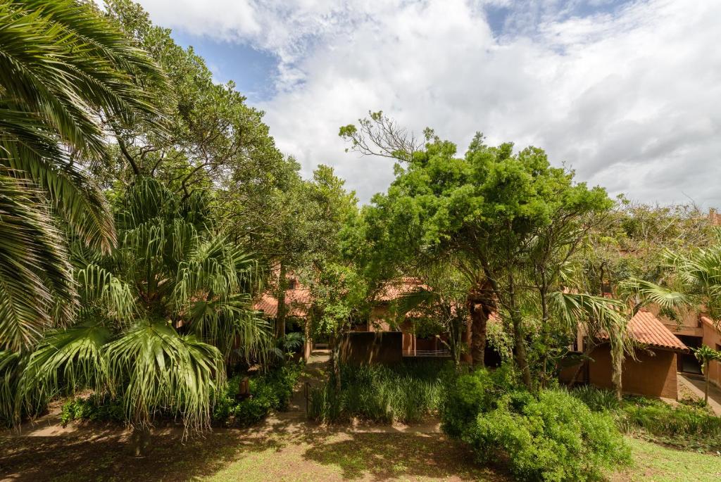 un jardín con palmeras y una casa en San Lameer Villa 3120 - 3 Bedroom Classic - 6 pax - San Lameer Rental Agency, en Southbroom