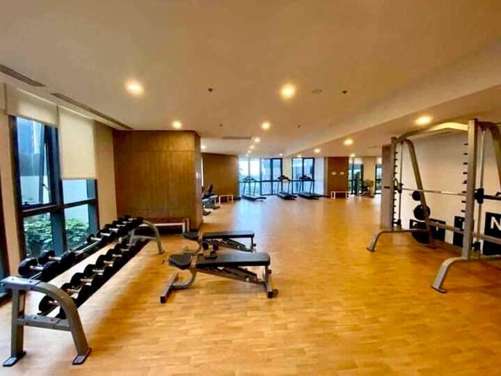 a gym with treadmills and benches in a large room at AFFORDABLE StayCation EASTWOOD CITY in Manila