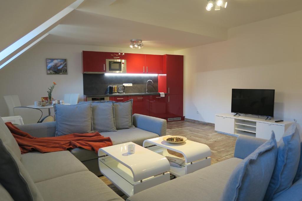 uma sala de estar com um sofá e uma televisão em Apartmán U Josefa em Sušice