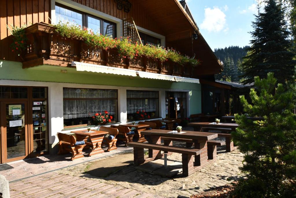 a building with tables and chairs in front of it at Penzión Lesnica in Spišské Tomášovce